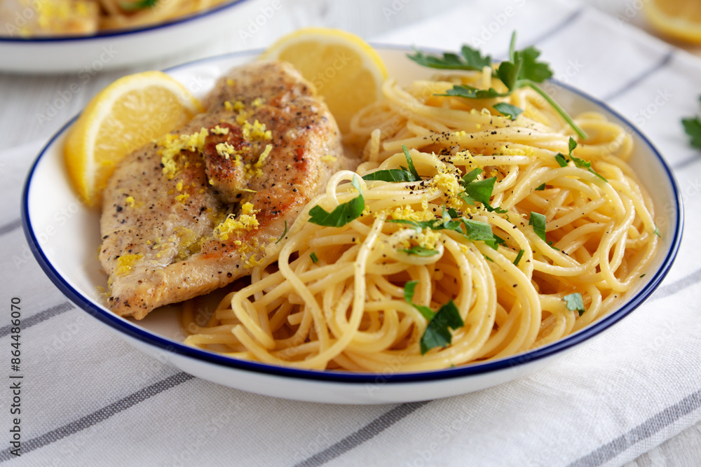 Homemade Lemon Pepper Chicken with Spaghetti Pasta on a Plate, side view. Homemade Lemon Pepper Chicken with Spaghetti Pasta on a Plate, side view.
