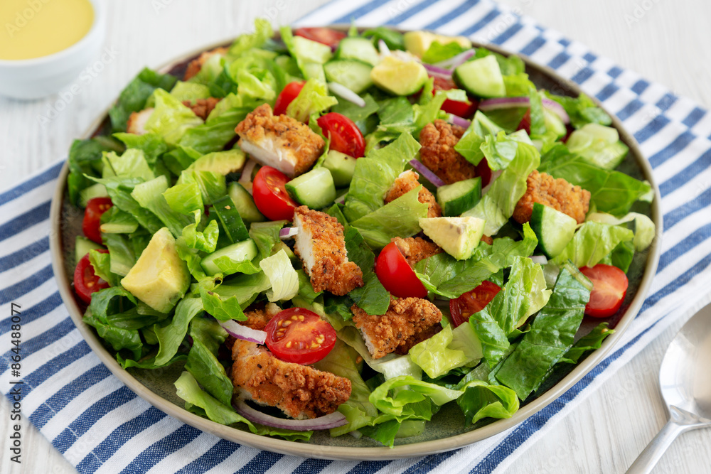 Homemade Crispy Chicken Salad with Tomato and Cucumber on a Plate, side view. Homemade Crispy Chicken Salad with Tomato and Cucumber on a Plate, side view.