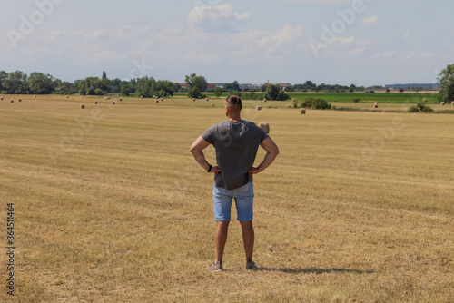 The man stay in agriculture field and looking away into the distance. photo