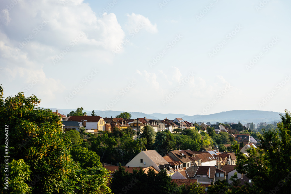 Orange brown tiled roof of the houses with solar panels. Traditional street. Amazing landscape with mountains and houses of Eger. Different size and colors building in Europe. Lifestyle of Hungary. Orange brown tiled roof of the houses with solar panels. Traditional street. Amazing landscape with mountains and houses of Eger. Different size and colors building in Europe. Lifestyle of Hungary.