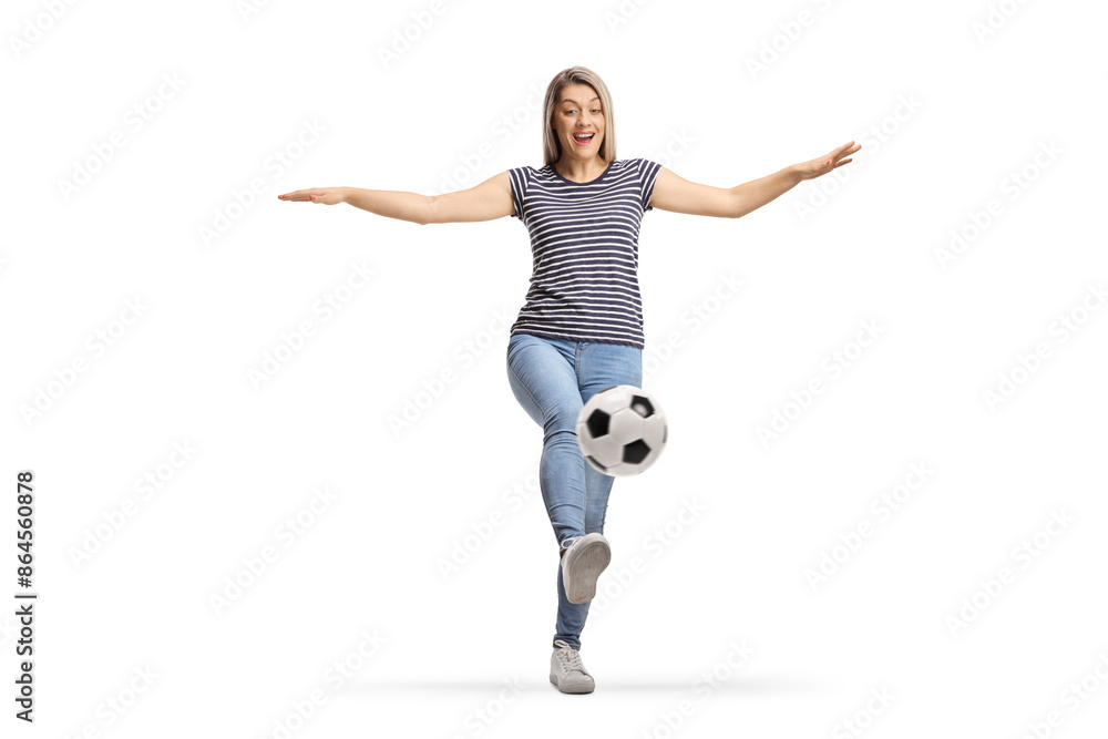 Young woman kicking a football Young woman kicking a football