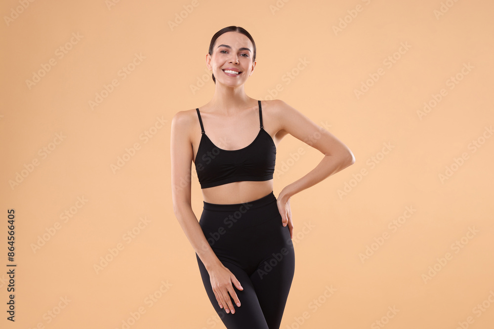 Obraz premium Diet and weight loss concept. Beautiful young woman with slim body against beige background