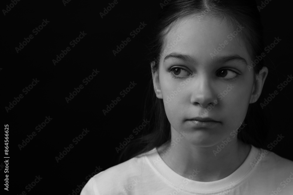Portrait of sad girl on dark background, space for text. Black and white effect Portrait of sad girl on dark background, space for text. Black and white effect