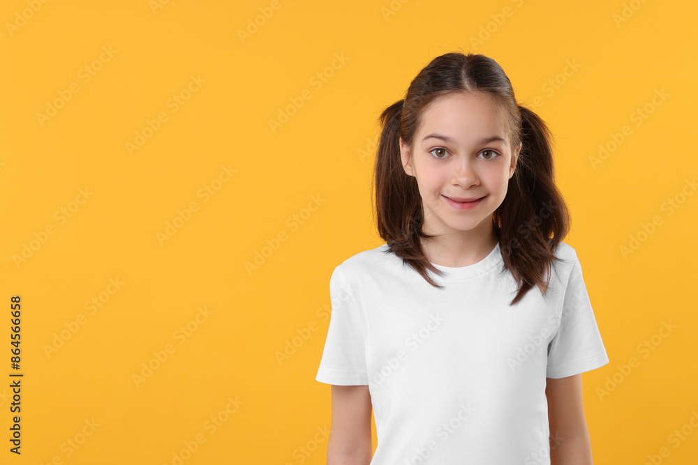 Portrait of beautiful girl on orange background, space for text Portrait of beautiful girl on orange background, space for text