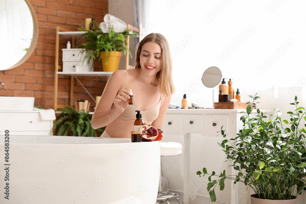 Young woman with pomegranate and serum in bathroom Young woman with pomegranate and serum in bathroom