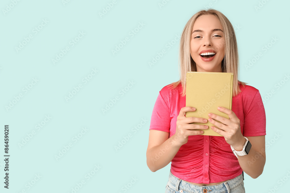 Beautiful young happy woman with book on blue background Beautiful young happy woman with book on blue background