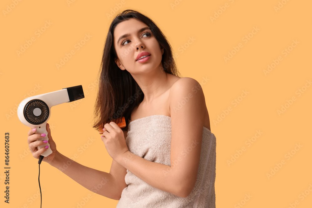 Beautiful young woman with towel, hair dryer and comb on yellow background Beautiful young woman with towel, hair dryer and comb on yellow background