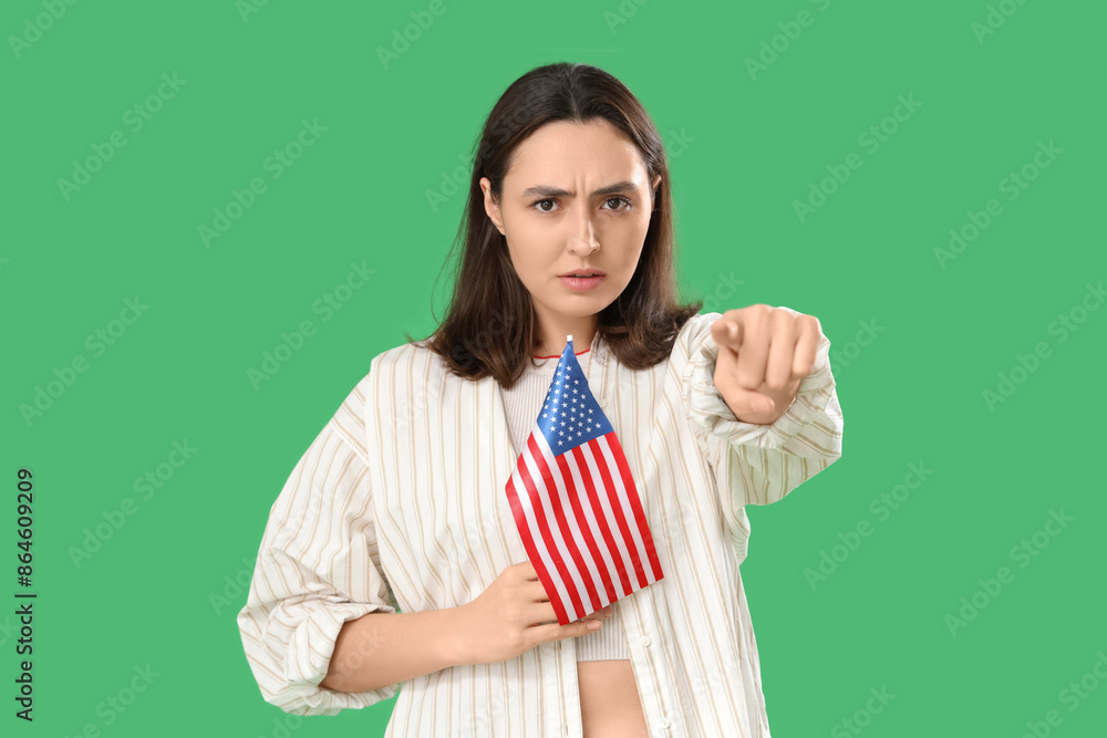 Young woman with USA flag pointing at viewer on green background. Accusation concept Young woman with USA flag pointing at viewer on green background. Accusation concept
