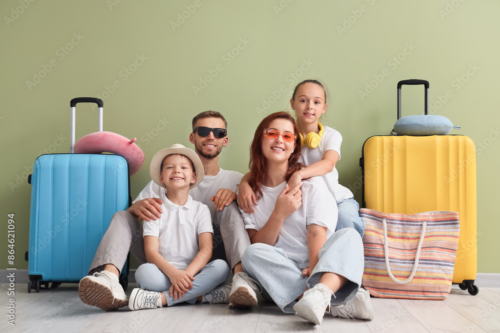 Family of tourists with suitcases sitting near green wall Family of tourists with suitcases sitting near green wall