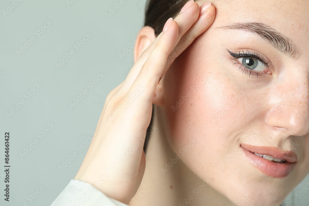 Young woman with beautiful eyebrow on light background, closeup and space for text Young woman with beautiful eyebrow on light background, closeup and space for text