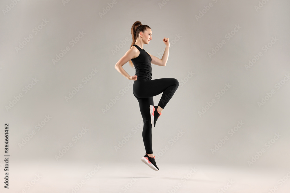 Young woman doing aerobic exercise on light background Young woman doing aerobic exercise on light background