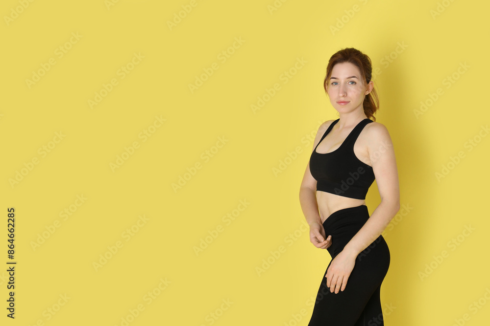 Woman with slim body posing on yellow background, space for text Woman with slim body posing on yellow background, space for text