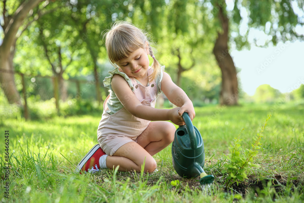 Fototapeta premium Cute little girl watering tree in garden
