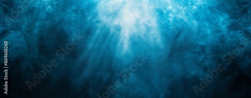 Abstract blue gradient background with a grainy texture and spotlight effect, creating a dark, moody ambiance. © klss777