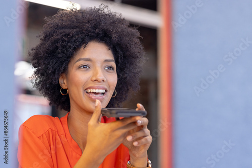 Holding smartphone and speaking, smiling woman engaging in casual business conversation