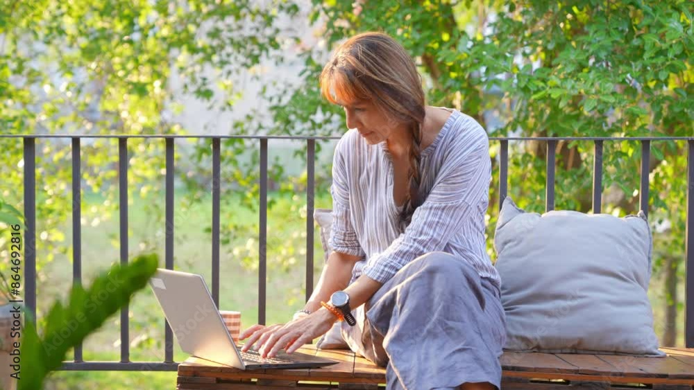 Asian mature woman freelance working on laptop computer with using AI at home. Businesswoman sitting at balcony and working online corporate business. Modern life and remote working technology concept Asian mature woman freelance working on laptop computer with using AI at home. Businesswoman sitting at balcony and working online corporate business. Modern life and remote working technology concept