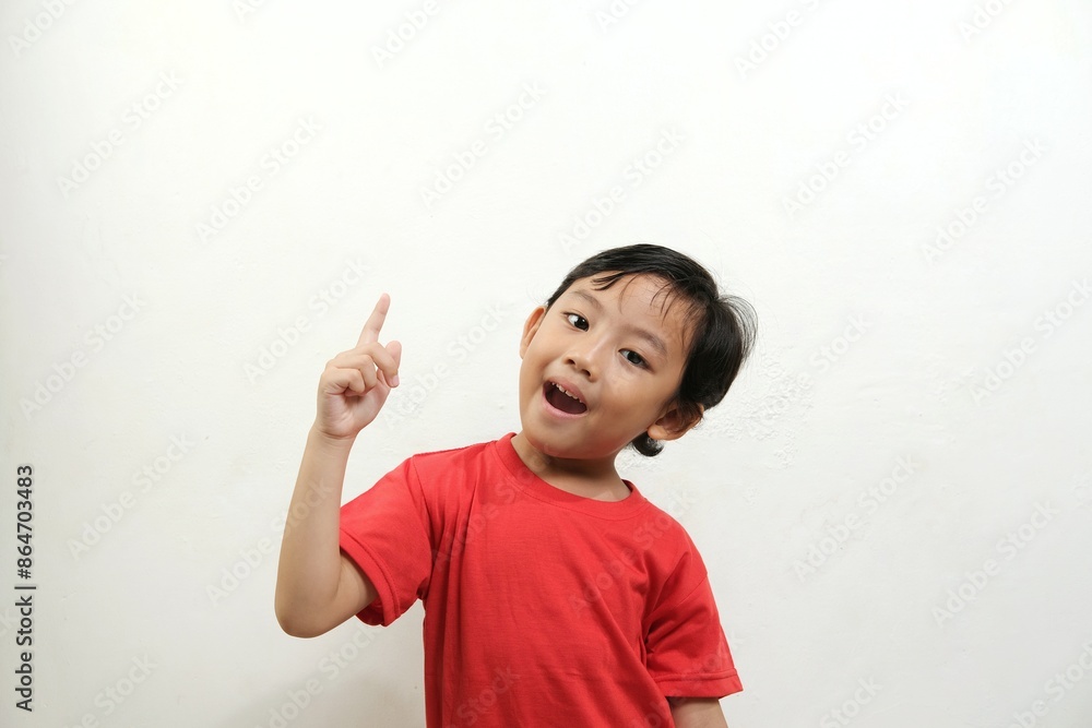 A cheerful boy in a red shirt points upwards with an excited expression, perfect for illustrating ideas, learning, creativity, and inspiration in educational or promotional content. A cheerful boy in a red shirt points upwards with an excited expression, perfect for illustrating ideas, learning, creativity, and inspiration in educational or promotional content.