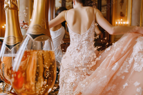 A woman in a pink dress is dancing and splashing champagne