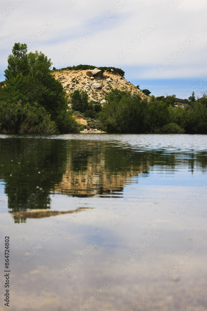 Scenic View of Rocky Hill with Reflection in Calm Lake Scenic View of Rocky Hill with Reflection in Calm Lake