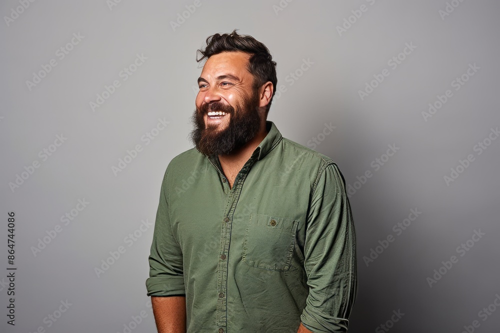 Portrait of a happy bearded man in a green shirt on a gray background Portrait of a happy bearded man in a green shirt on a gray background
