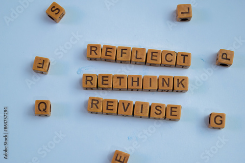 Concept of Reflect, Rethink, Revise written on wooden blocks. Cross processed image on Wooden Background photo