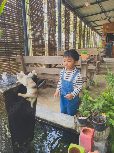 Wallpaper Mural Hispanic child enjoying gardening outdoors with potted plants and watering them in the summer Torontodigital.ca
