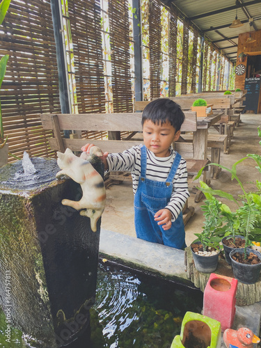 Wallpaper Mural Hispanic child enjoying gardening outdoors with potted plants and watering them in the summer Torontodigital.ca