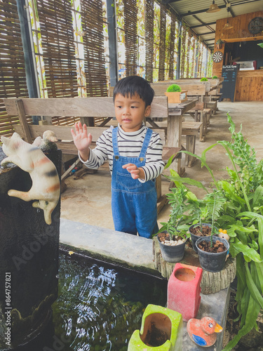 Wallpaper Mural Hispanic child enjoying gardening outdoors with potted plants and watering them in the summer Torontodigital.ca