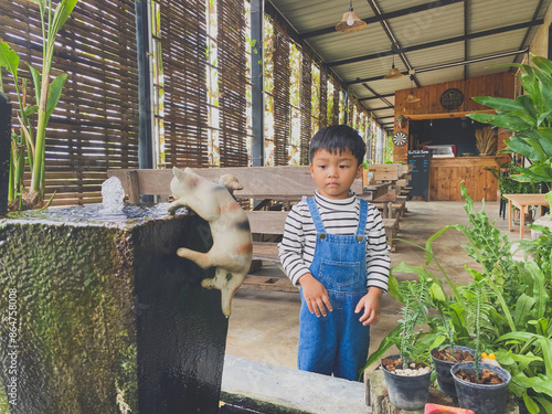 Wallpaper Mural Hispanic child enjoying gardening outdoors with potted plants and watering them in the summer Torontodigital.ca