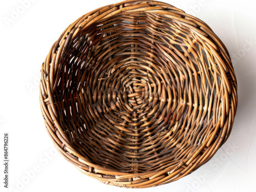 A basket made of wicker sits on a white background. The basket is empty and has a rustic, natural feel to it