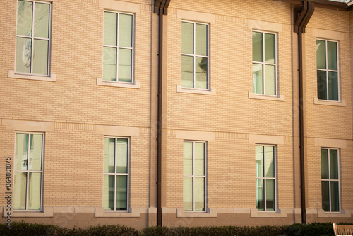 Multi-story building with sun shining directly on wall. Beige stucco exterior wall