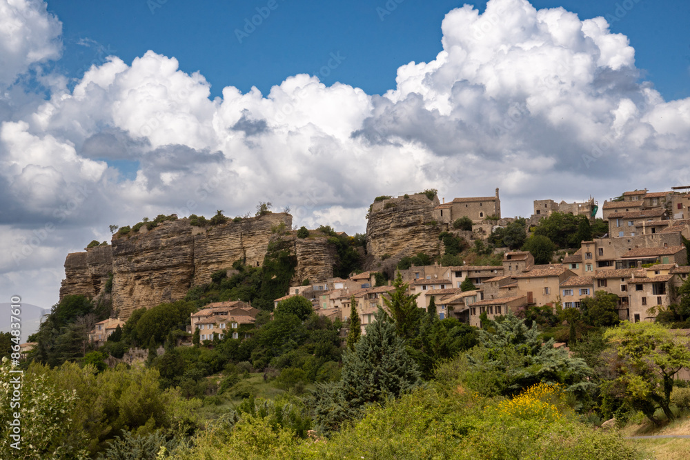 The high-altitude village of Saignon. A small village in the middle of the mountainous landscape of the Great Lubéron, Provence, France. Blue sky with striking white clouds The high-altitude village of Saignon. A small village in the middle of the mountainous landscape of the Great Lubéron, Provence, France. Blue sky with striking white clouds