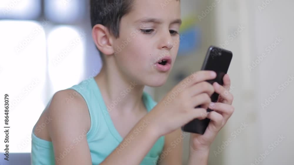 Kid playing mobile game on smartphone at home Kid playing mobile game on smartphone at home