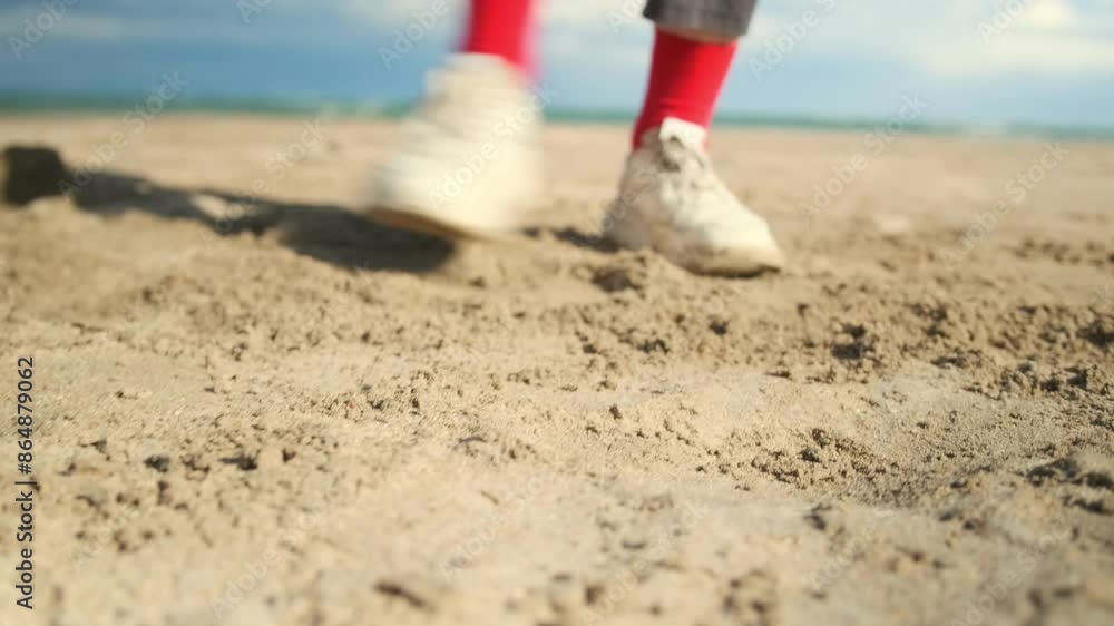 Dancer's feet dancing in bright red socks on the sand close-up against the background of ocean waves, coastline and blue sky. Dancer's feet dancing in bright red socks on the sand close-up against the background of ocean waves, coastline and blue sky.