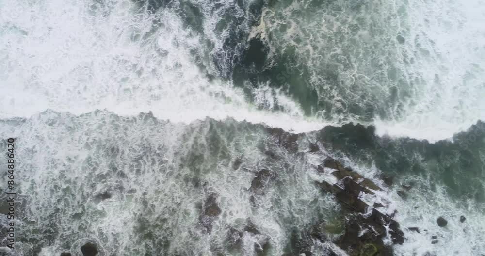 aerial drone video of foam waves on a rocky shore in a cloudy day aerial drone video of foam waves on a rocky shore in a cloudy day