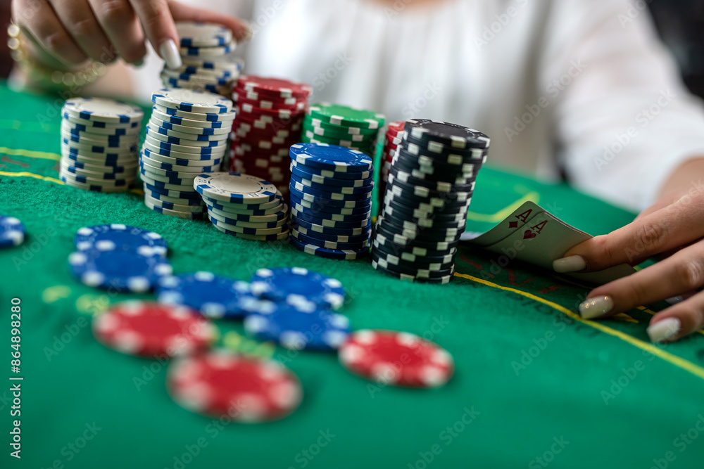 female hands pick up poker chips from a pile at a round poker table. risky bets in poker female hands pick up poker chips from a pile at a round poker table. risky bets in poker