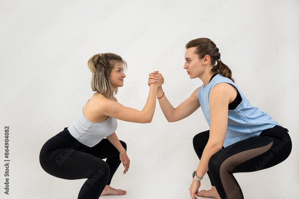 Young healthy two women doing workout pilates exercise together isolated