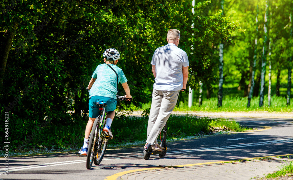 Obraz premium Cyclists ride on the bike path in the city Park