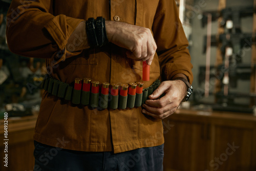 Canvas-taulu Closeup of hunter hands placing bullets into the ammo belt