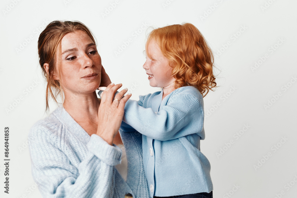 Mother and daughter together teaching good dental hygiene with a toothbrush in a warm family moment Mother and daughter together teaching good dental hygiene with a toothbrush in a warm family moment