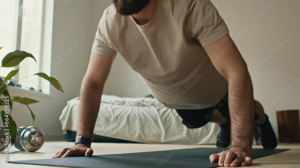 Strength training. Close up of bearded guy doing push ups exercise at home
