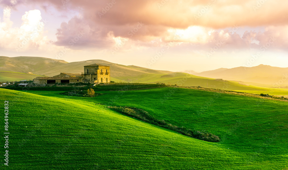 countryside sunset in green hills of spring fields with old castle farm and mountains on background of evening landscape countryside sunset in green hills of spring fields with old castle farm and mountains on background of evening landscape