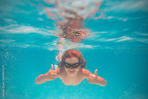 Child playing in swimming pool. Kids holidays and vacation concept. Summer kid play in swimming pool. Little child boy in pool underwater. Kids swim in pool on summer vacation.