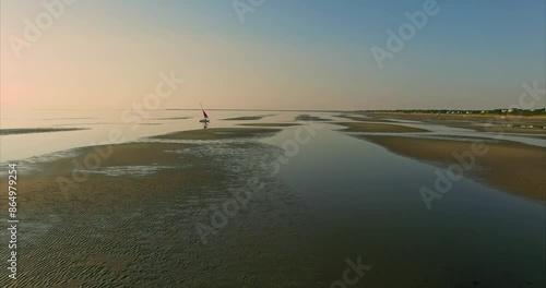 Small sailboat in tranquil calm water at sunset, giving the feeling of bliss. First Encounter Beach, Cape Cod, Massachusetts, United States of America. photo