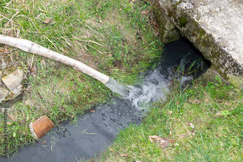 Water flows into the ditch from a hose. photo