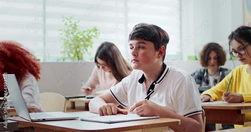 Camera moving around group of pupils. Caucasian children studying during class in school. Writing down or noting something in notepad. Using pens and pencils. Learning new information. Camera moving around group of pupils. Caucasian children studying during class in school. Writing down or noting something in notepad. Using pens and pencils. Learning new information.