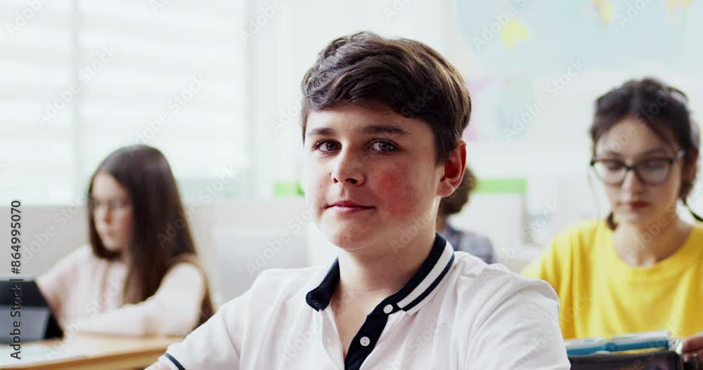 Camera moving around while keeping focus on Caucasian boy. Pupil listening to teacher during class. Glancing at camera while smiling widely. Positive attitude. Modern classroom. Interesting lesson. Camera moving around while keeping focus on Caucasian boy. Pupil listening to teacher during class. Glancing at camera while smiling widely. Positive attitude. Modern classroom. Interesting lesson.