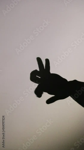 Shadow puppetry hand movements on plain background