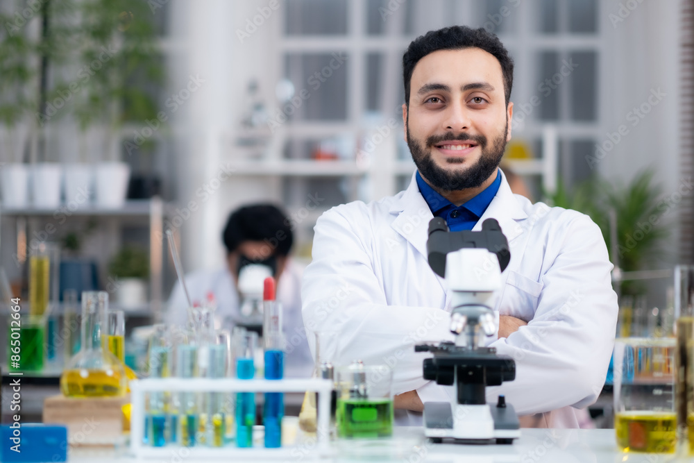 Portrait of confident medical researcher in laboratory with microscope smilling, looking at camera and cross his arm in laboratory. Portrait of confident medical researcher in laboratory with microscope smilling, looking at camera and cross his arm in laboratory.