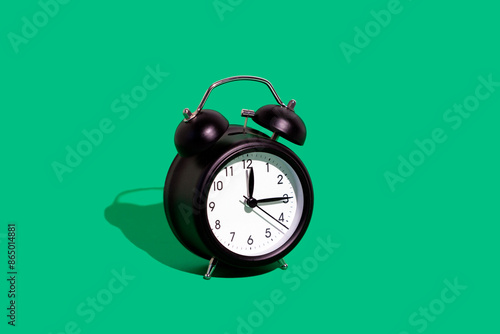 Retro alarm clock against green background